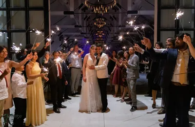 married couple with sparklers and guests