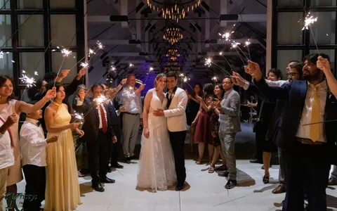 married couple with sparklers and guests