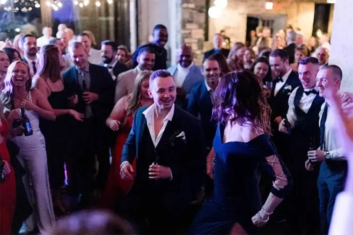 bride and groom smiling with friends at their wedding
