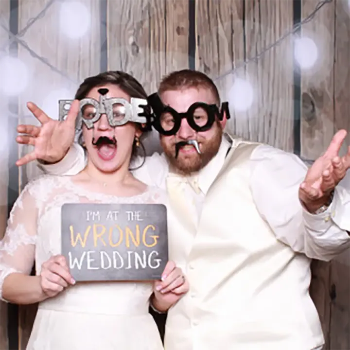 a couple taking photos at a wedding in a photo booth