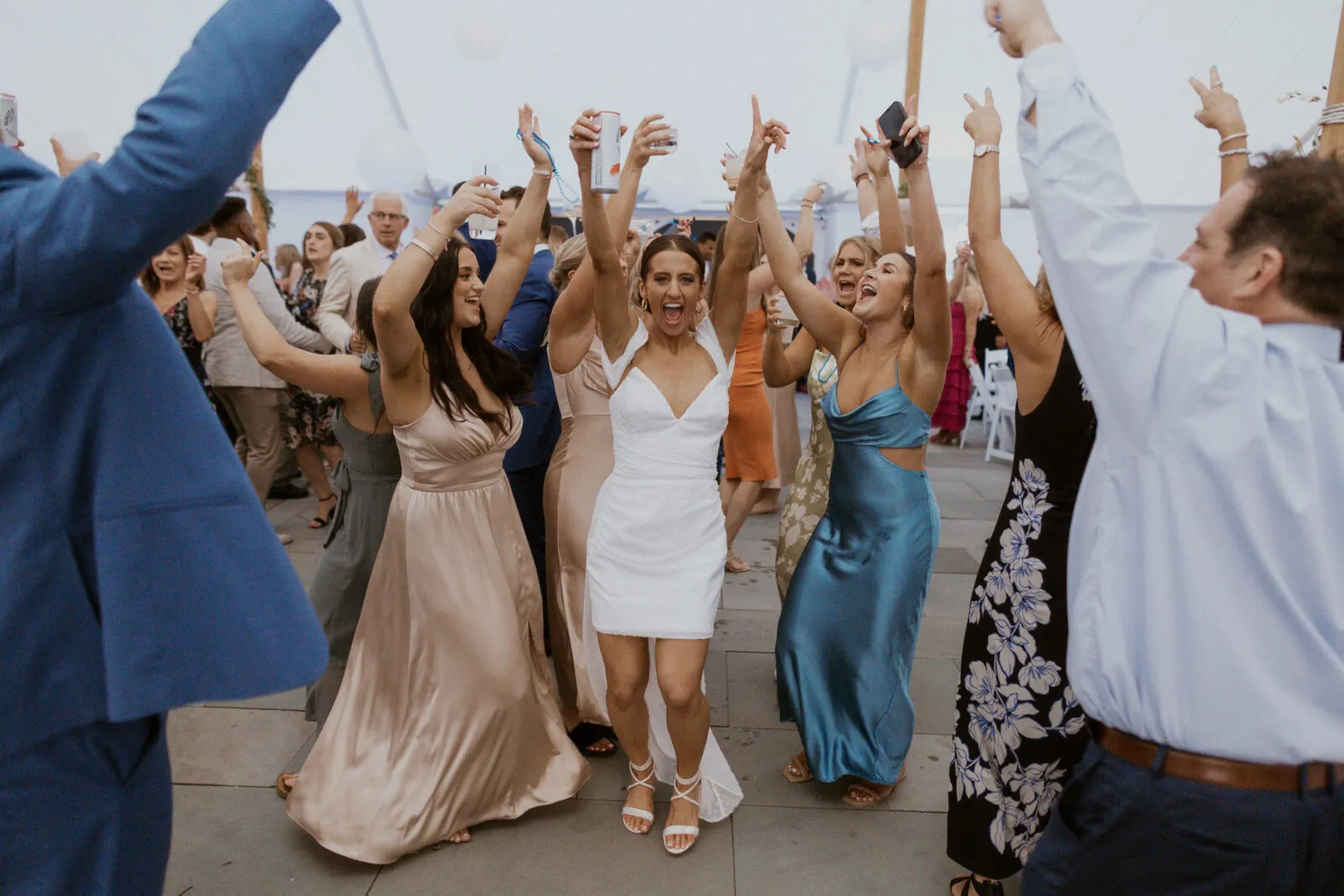Guests dancing under string lights at Sydney and Brady’s tent wedding reception