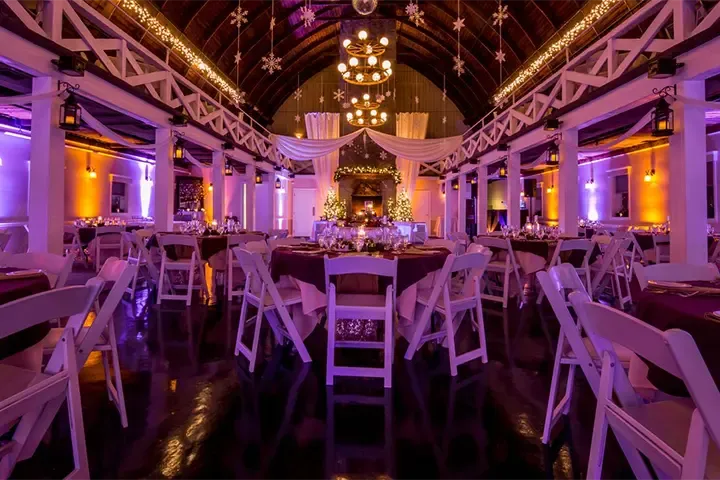 wedding event venue with full room lighting in tones of purple and gold