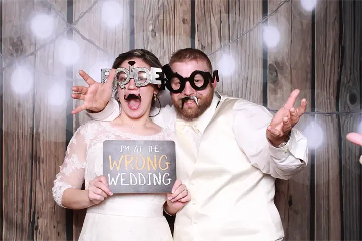 wedding guests taking fun pictures in a photo booth